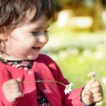 happy-little-girl-in-sunny-flower-field-picture-id1138650236