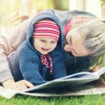 mother-and-little-baby-girl-reading-book-together-on-blanket-outdoors-picture-id820953278