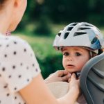 mother-putting-a-helmet-on-her-sons-head-picture-id922713048